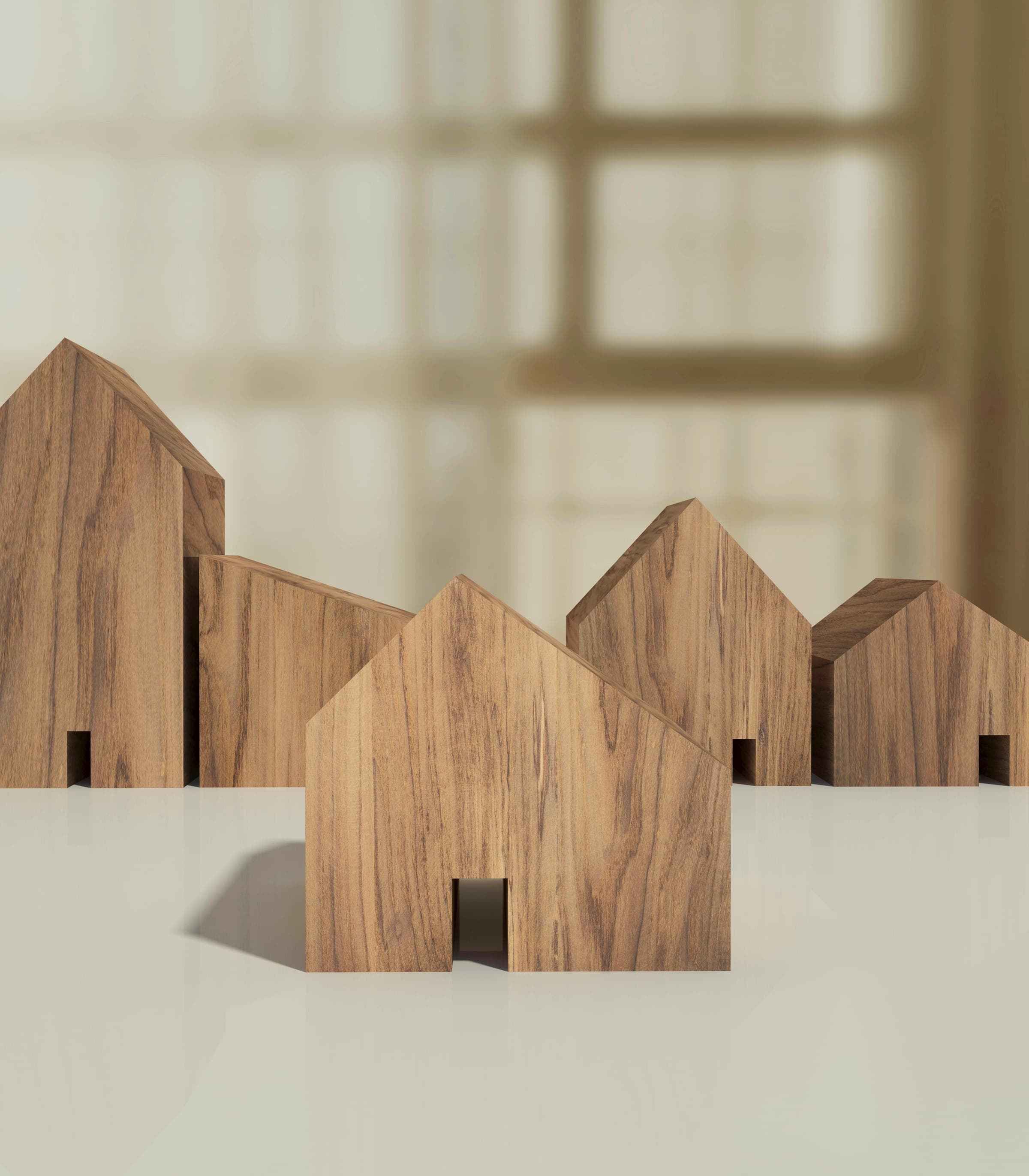 Casette in legno minimaliste disposte su una superficie chiara, in luce morbida — l'immagine di marca di MC Real Estate.